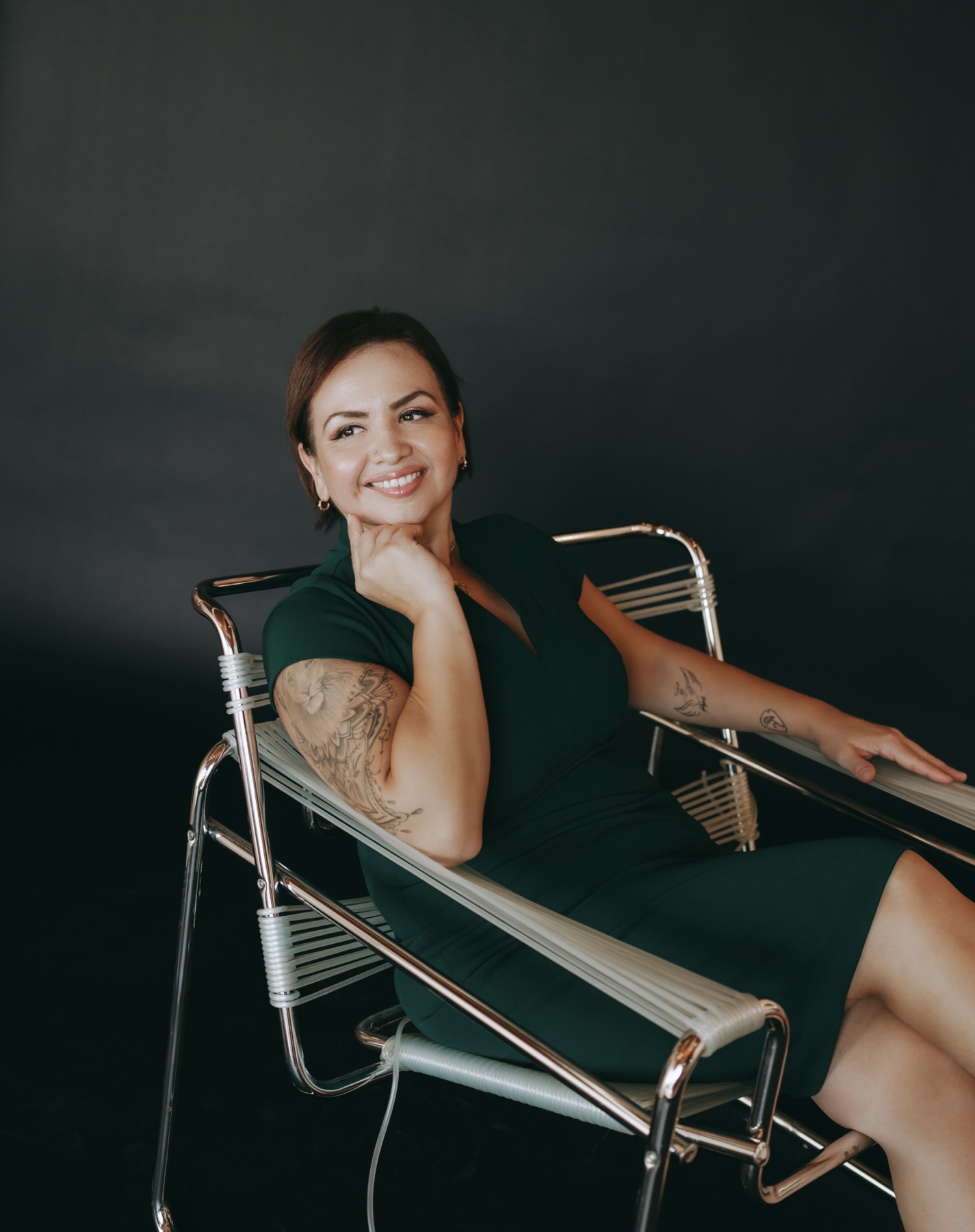 Jessica Sanchez seated in a chrome chair, looking away from camera