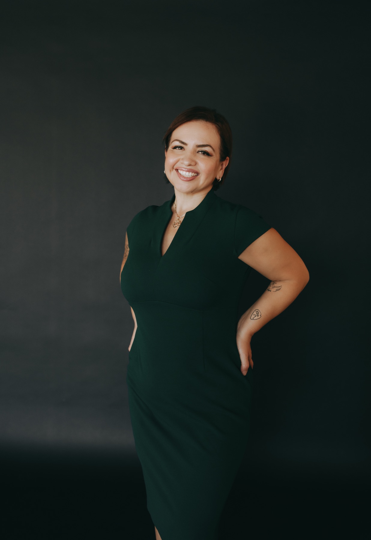 Jessica Sanchez, founder of Lion's Gem, standing in a deep green dress